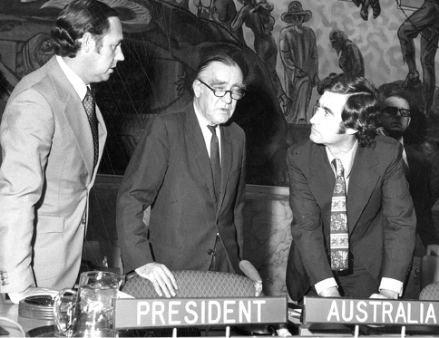 The Australian Permanent Representative to the United Nations and President of the UN Security Council for October, Sir Laurence McIntyre (centre), talks with officers of the Australian permanent mission to the United Nations, Duncan Campbell (left) and Charles Mott (right), during the debate on the Middle East following the Arab–Israeli war, New York, c. 22 to 26 October 1973. [UN Photo/Max Machol]