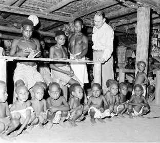 The Australian Minister for Territories, Paul Hasluck, inspects the schoolwork at Bamu River Mission, Papua and New Guinea, 1955. [National Archives of Australia]