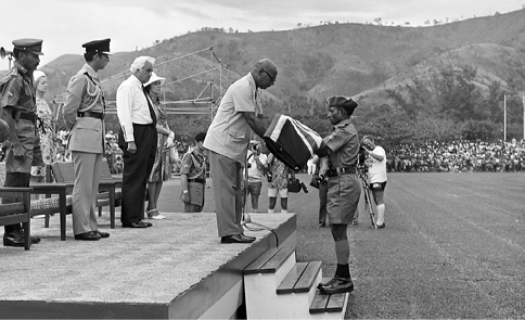 The Australian flag is passed to the inaugural Governor-General of the new nation of Papua New Guinea, Sir John Guise, watched by the Commander of the PNG Defence Force, Brigadier General Ted Ramu Diro (left), HRH Prince Charles (second left) and the Australian Governor-General, Sir John Kerr (third left), in a sunset ceremony which saw the flag lowered for the final time in the former Australian territory, Port Moresby, 15 September 1975. [National Archives of Australia]