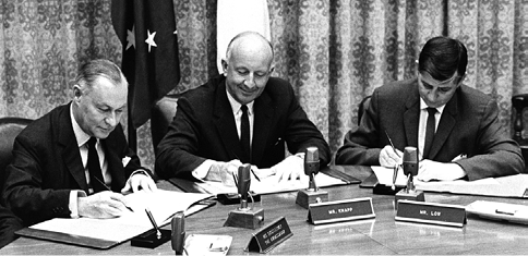 The Australian Ambassador to the United States, Sir Keith Waller (left), a Vice President of the World Bank, J Burke Knapp (centre), and the Australian Minister Financial Washington, GA Low, sign the documents for the first World Bank loan, guaranteed by the Commonwealth of Australia, for economic development in the Territory of Papua and New Guinea administered by Australia, Washington DC, 28 June 1968. [World Bank/Edwin G Huffman]