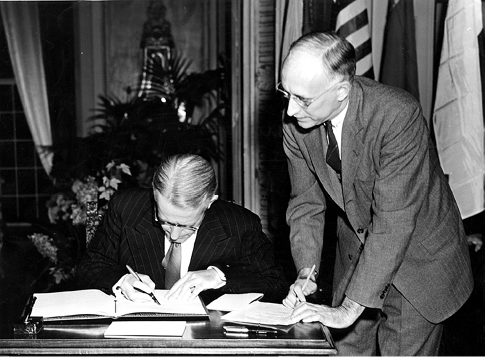 The Australian High Commissioner in Canada, Alfred T Stirling (left), signs the Food and Agriculture Organization Agreement on behalf of Australia, assisted by the FAO Secretary-General, Walter E Sharp, Quebec City, 1945. [National Film Board of Canada Collection/Library and Archives Canada]