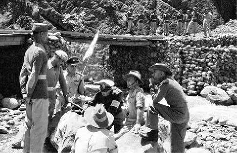 The UN Military Observer Group meet with Indian and Pakistani officers on the ceasefire line in Kashmir, 1 January 1955. Left to right: Two Pakistani officers; Major JD Murray (Australia); Major Emilio Altieri (Uruguay); Lieutenant Colonel RH Marson (Australia); an Indian officer; and, back to camera, Major FH Moy (Australia). [UN Photo/SC]