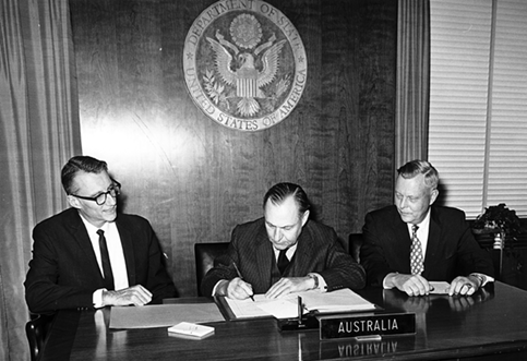 The Australian Ambassador to the United States, Sir Keith Waller (centre), signs the Nuclear Non-Proliferation Treaty, watched by the Deputy Director, US Arms Control and Disarmament Agency, Philip J Farley (left), and Under Secretary of State U Alexis Johnson (right), Washington, 27 February 1970. [US Department of State/Robert H McNeill]