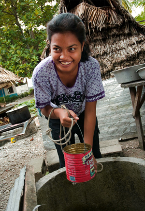 Eritiama Boraia pulls a bucket of water from a well.