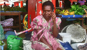 Woman at markets in rural Vanuatu talking on mobile phone