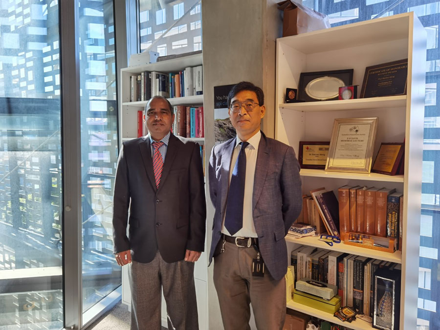 Dr Sanjay Nimbalkar and DProf Daichao Sheng at UTS, in an office, by a window.