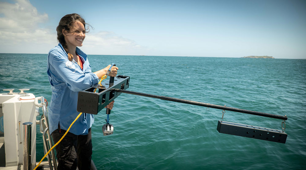 Woman deploying a mid-water baited video system into the ocean