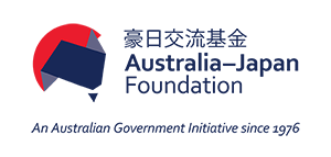 Logo of the Australia–Japan Foundation featuring a stylized map shape in dark blue over a red circle, with bilingual text in Japanese and English reading '豪日交流基金 Australia–Japan Foundation'. Tagline below states 'An Australian Government Initiative since 1976'.