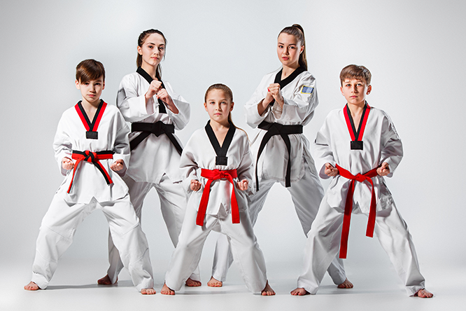 Children in Taekwondo uniforms posing in fighting stances
