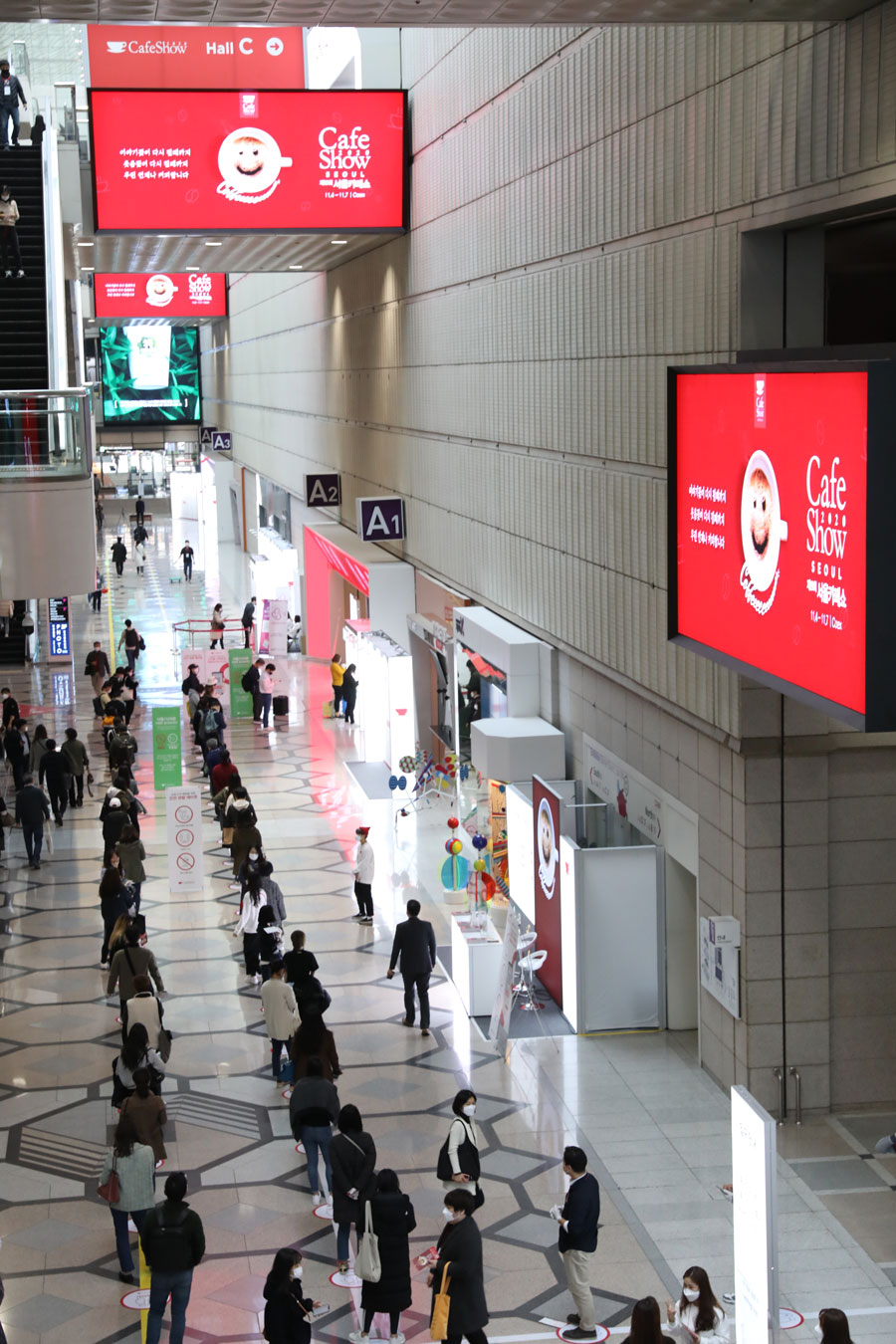 A photo showing the entrance of the 19th Seoul International Café Show with many people lining up to go in. 