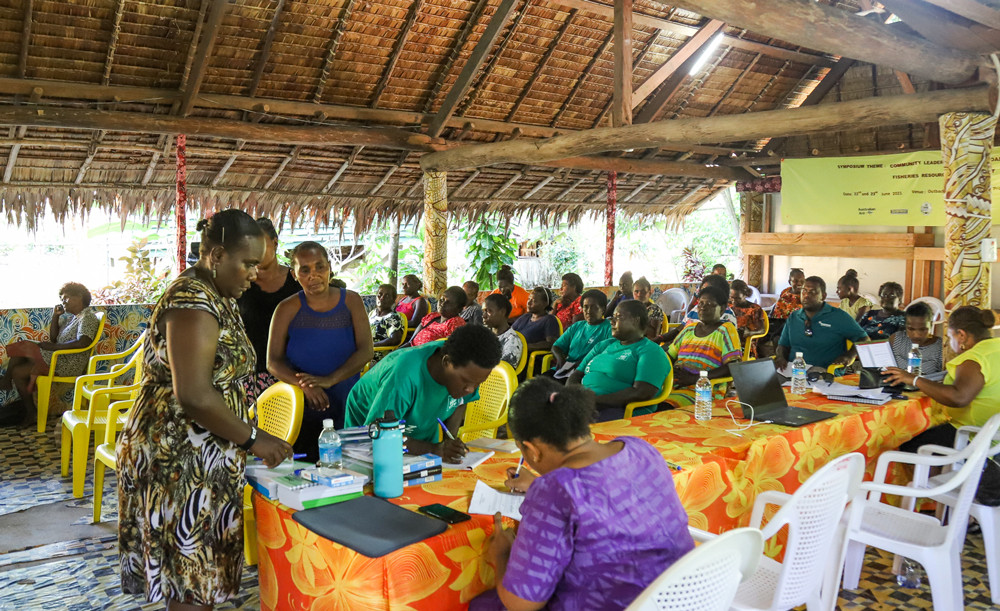 Photo of several participants gathered under a local Solomon Islands building. 