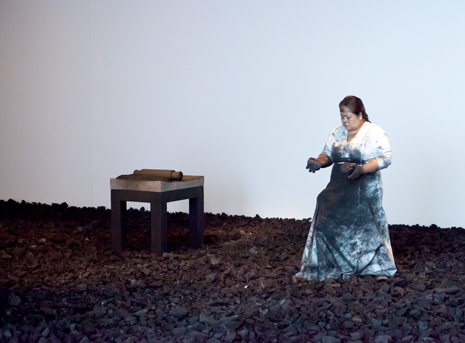Lady with dark rocks, walking on rocks with a table in background