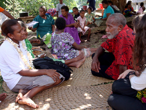 A group of people sitting on the ground talking