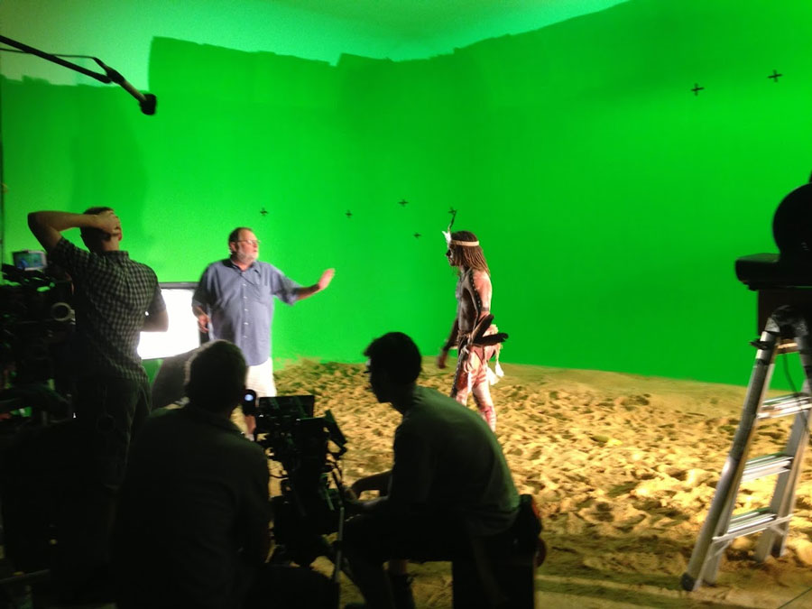 Photo of a production director giving an actor directions on set. 