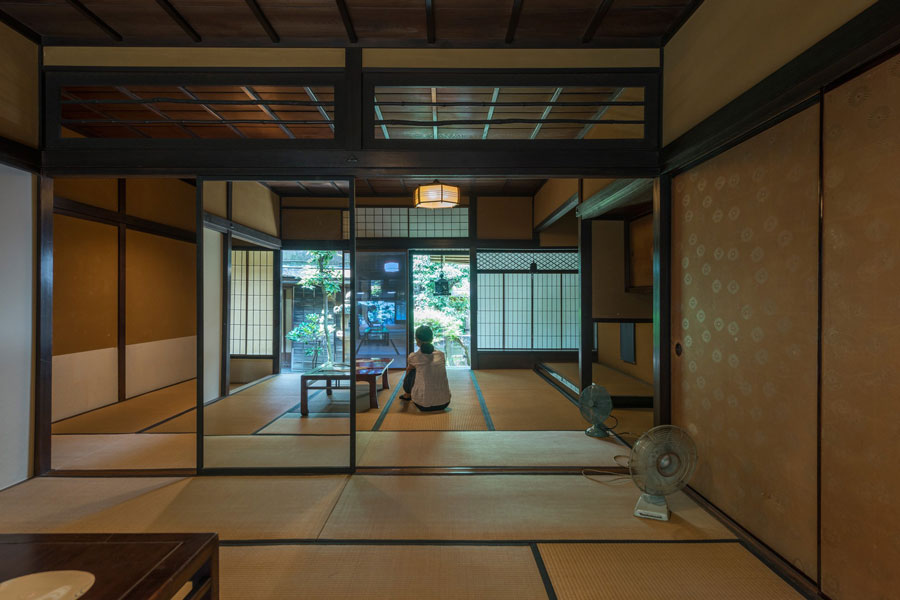 Photo of a women sitting on the floor of a tradition Japanese style house. 