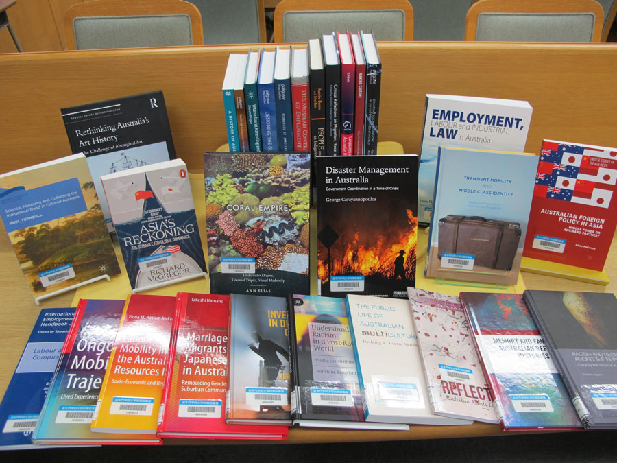 Photo of bunch of books laid out on a desk.