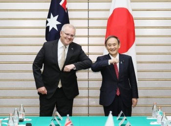 Photo of Australian PM undertaking a COVID-19 safe elbow bump with Japan PM. 