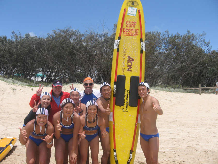 Photo of Japanese students undertaking surf lifesaving training on an Australian beach. 
