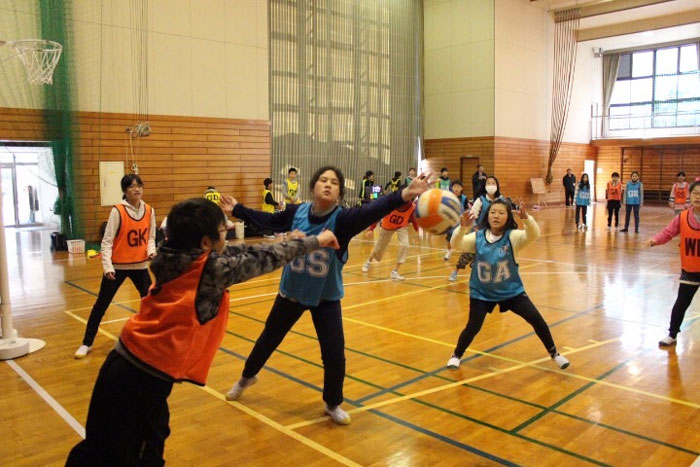 Photo of Japanese students playing a game of netball. 
