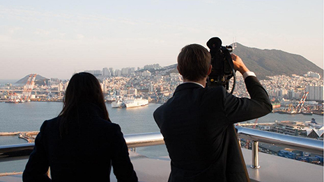 The back of Janda and Lee filming, camera pointed at a mountain