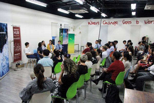 Room full of people listening to a panel discussion