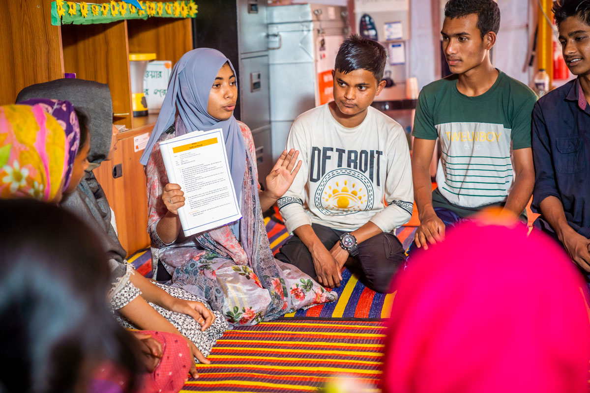 Group of Bangladesh youth sitting down in discussion.