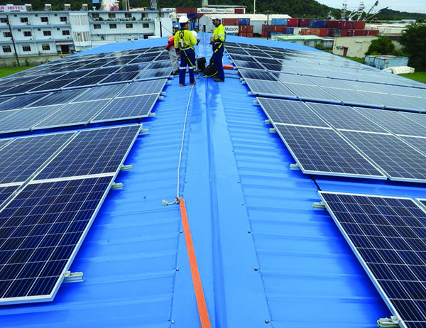 Workers on a roof installing solar panels