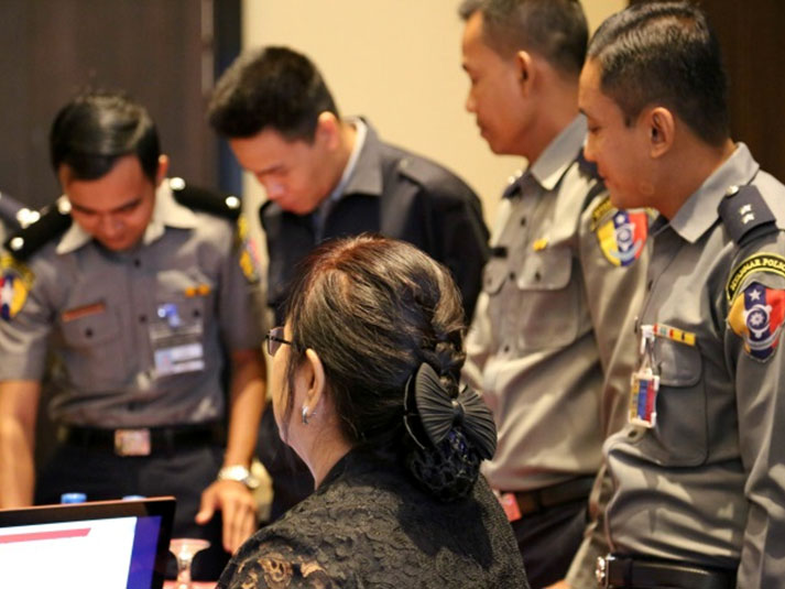 Uniformed law enforcement officers standing in a meeting room.