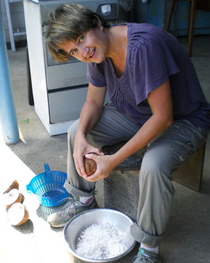 Monika seated, with a coconut in hand