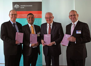 Photo of four men each holding a book and smiling