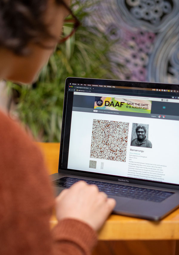 Photo of person on Laptop looking at the DAAF Save the Date August 2021 event. 