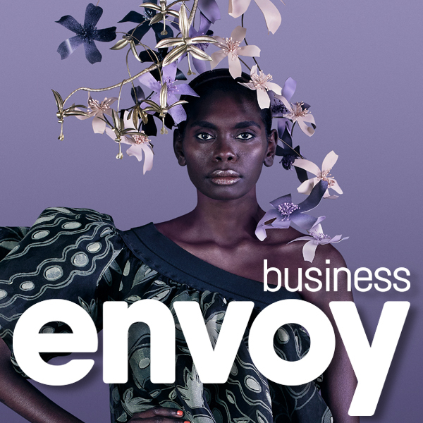 Indigenous model in a dress with puffy sleeve on right shoulder and headdress of flowers