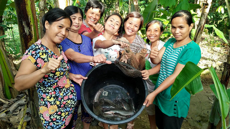 Women and bucket of catfish