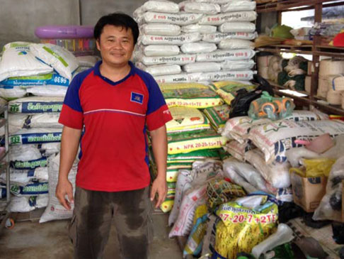 Mr Sim Ratana at his business with bags of fertiliser
