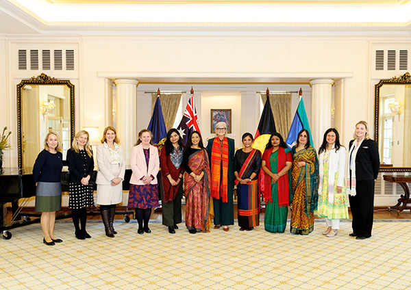 Twelve people standing in a formal room at Government House in Canberra with the Governor-General, posing for a photo in front of Australian, Aboriginal, and Torres Strait Islander flags.