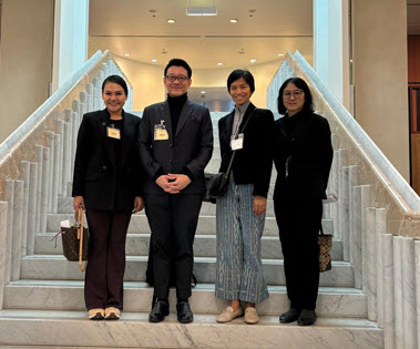 four people standing together on a staircase inside Parliament House