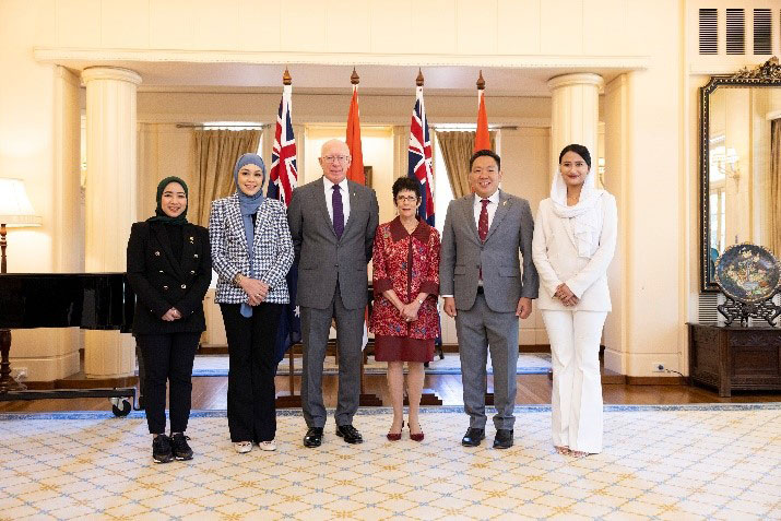 Their Excellencies Governor General and Mrs Hurley with four Indonesian delegates, three female one male. Behind them are the flags of Australia and Indonesia.