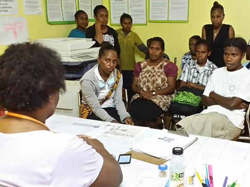 A woman talking to an attentive group of people