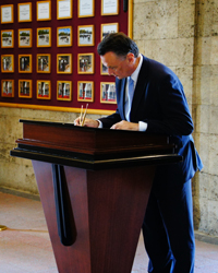 Image of Minister Emerson signing the memorial book at the mausoluem for Atatürk, the founder of the Turkish Republic. A guard is standing in the doorway watching him.