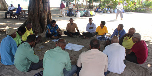 People having a group discussion sitting on the floor in a circle.