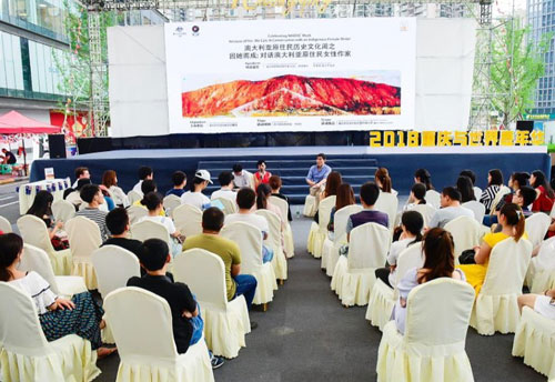 Distant photo of Dr Leane and Zhou Xiaoping presenting on a stange infront of a local audience.