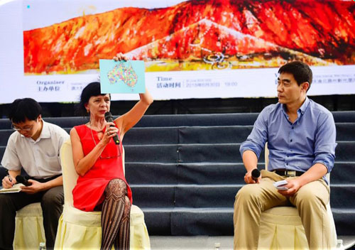 Close up photo of Dr Leane and Zhou Xiaoping presenting on a stange infront of a local audience.