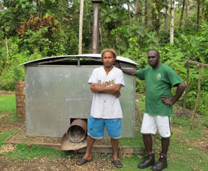 Collin Potakana of AusAID and Eric Potale standing in front of a cocoa mini-drier