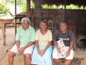 Moddy Theretoona sitting on a bench at her cocoa farm