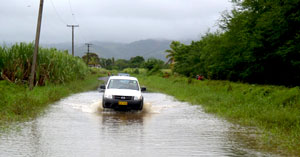 Car driving through flood waters.