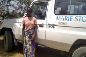 Teenage girl standing next to a Marie Stopes 4-wheel drive vehicle
