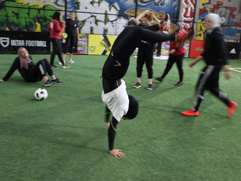 Photo of a woman doing a hand stand.