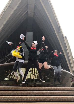 Photo of woman jumping infront of the Sydney Opera House.
