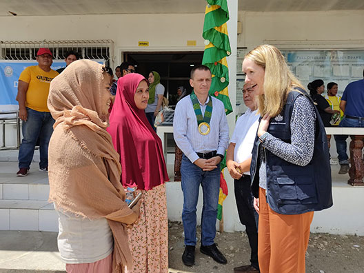 Australian government official talking to two Muslim women