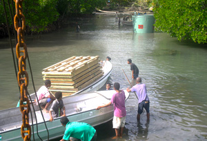Men unloading cargo into dinghies